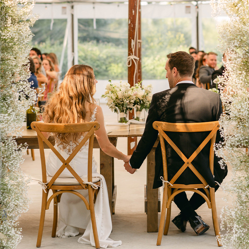 bride-and-groom-seated-under-a-canopy-of-small-white-flowers