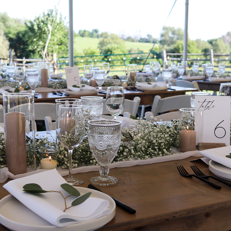 elegant-table-setting-with-clear-glass-and-black-cutlery-for-a-corporate-event-tent-package