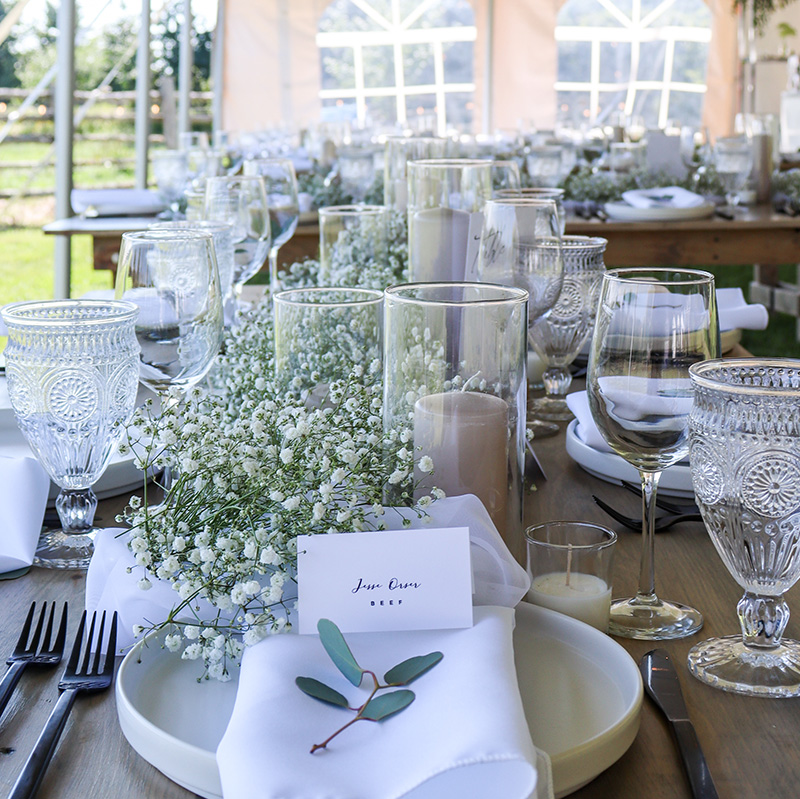 elegant-table-setting-with-white-linens-and-plate-chargers-and-babies-breath-flowers
