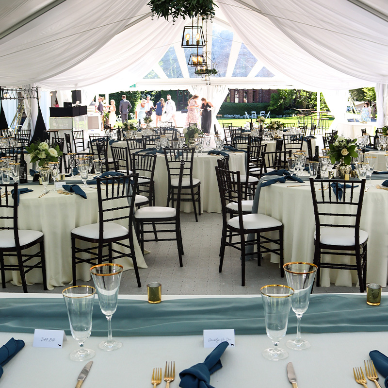 wedding-tent-canopy-interior-with-black-chairs-and-gold-accents